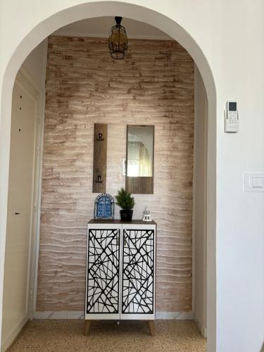 a hallway with a brick wall and a table with a plant at Dar Yassine in Sahline
