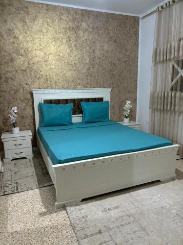 a bedroom with a large bed with blue pillows at Dar Yassine in Sahline