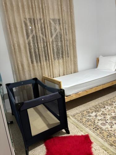 a bed and a chair in a room with a curtain at Dar Yassine in Sahline