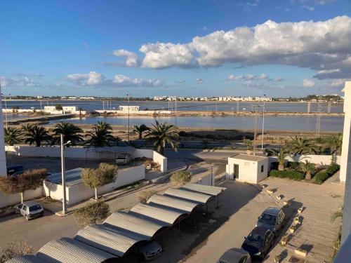a parking lot with cars parked in front of a harbor at Dar Yassine in Sahline