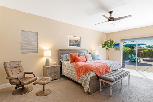 a bedroom with a bed and a chair and a window at Stunning 5 Star Oasis in Palm Springs