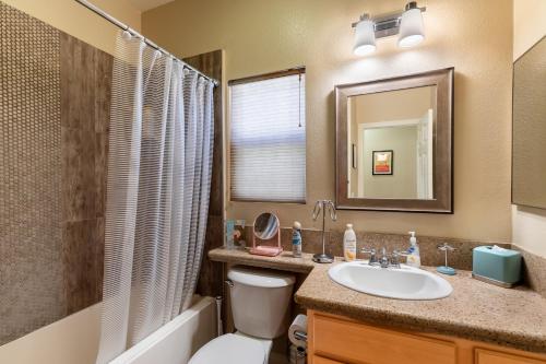 a bathroom with a sink and a toilet and a mirror at Stunning 5 Star Oasis in Palm Springs