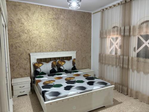 a bedroom with a bed with a black and white comforter at Dar Yassine in Sahline