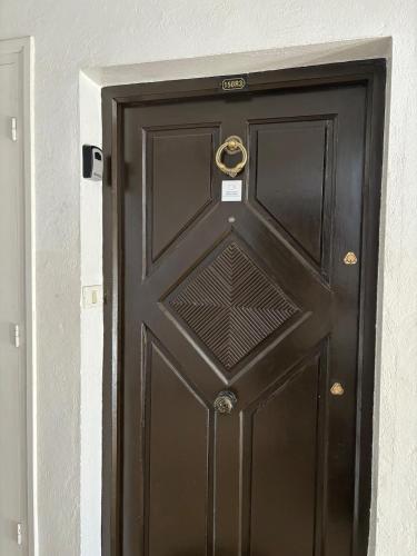 a black door with a gold knocker on it at Dar Yassine in Sahline