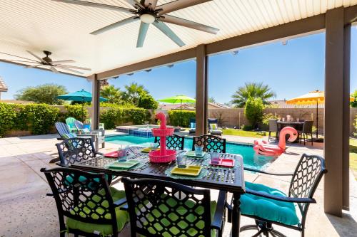 a patio with a table and chairs in front of a pool at Stunning 5 Star Oasis in Palm Springs