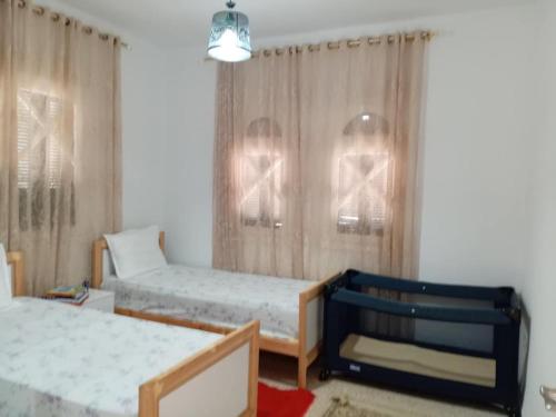 a bedroom with two beds and a window at Dar Yassine in Sahline
