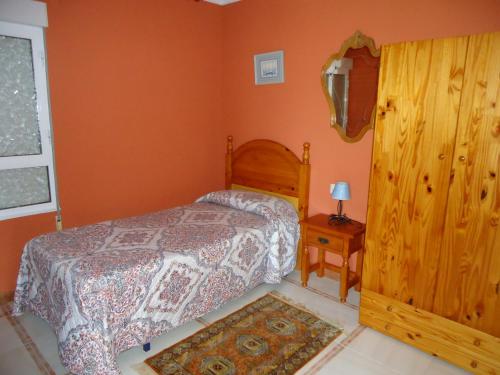 a bedroom with a bed and a table and a window at La Coruxa in Los Cabos