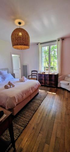 une chambre avec un grand lit et une grande fenêtre dans l'établissement Le Domaine Lieu Bill, Normandie, à Blonville-sur-Mer