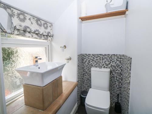 a bathroom with a sink and a toilet at Bank Cottage in Bradwell