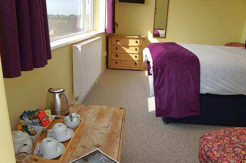 a bedroom with a bed and a table and a table sidx sidx sidx at Radcliffe Guest House in Ross on Wye