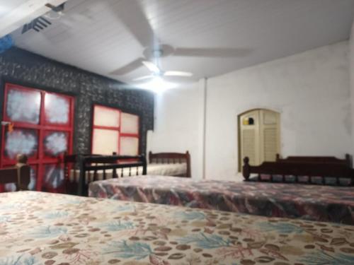 a room with two beds and a piano at Suíte Albergue em Casa de Excursão in Cabo Frio