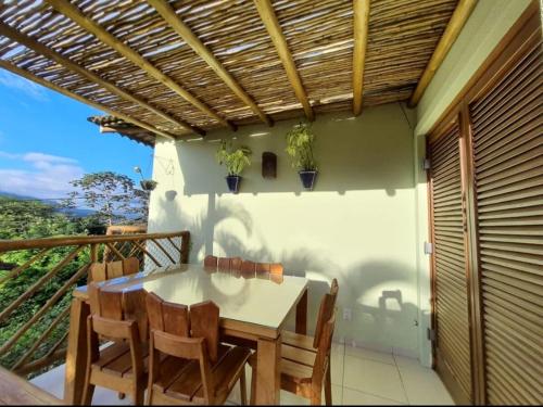 Residência em condom, 1 ou 2 suítes, vista para o mar, Praia do Curral, Ilhabela في إلهابيلا: غرفة طعام مع طاولة وكراسي على شرفة