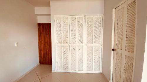 an empty room with a white closet and a door at Hotel Casa Barlovento, Parque Tayrona in Los Naranjos