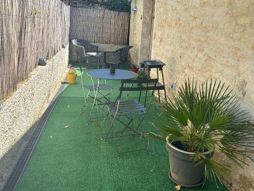 a patio with a table and chairs and a potted plant at Studio in Nanteuil-en-Vallée