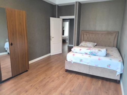 a bedroom with a bed and a wooden floor at Home away home in Mekhrably