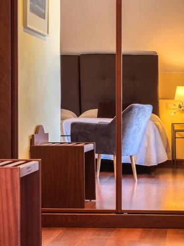 a mirror in a room with a bed and a chair at Hotel Verdemar in Ribadesella