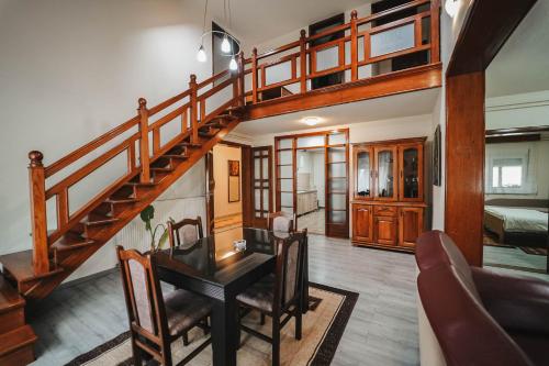 a living room with a wooden staircase and a table at B&B Passage in Sremska Mitrovica