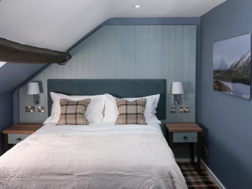 a bedroom with a large bed with two night stands at The Bryntirion Inn in Llandderfel