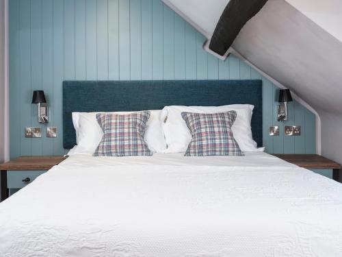a bedroom with a white bed with two pillows at The Bryntirion Inn in Llandderfel
