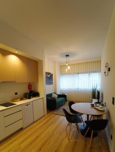 a kitchen and a living room with a table and chairs at Crystal Palace Oporto Flat - With Two Bedrooms in Porto