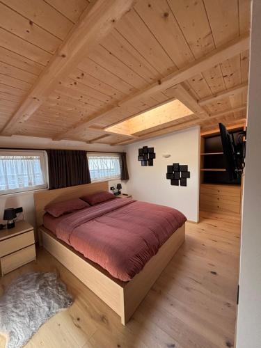1 dormitorio con 1 cama grande en una casa en Appartamento Cima 12, en Pozza di Fassa