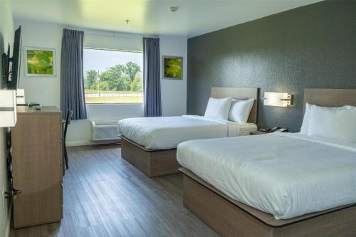 a hotel room with two beds and a window at Americas Best Value Inn Donaldsonville in Donaldsonville