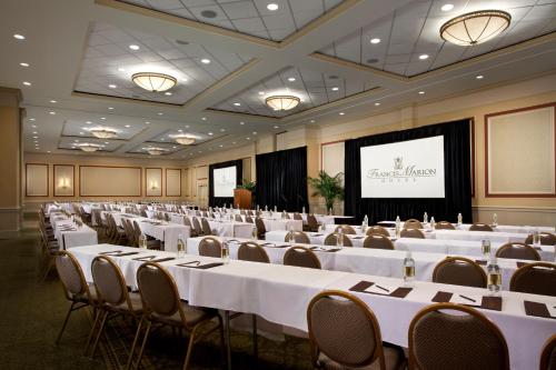 a conference room with tables and chairs and a screen at Francis Marion Hotel in Charleston
