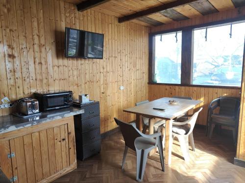 una cucina con un tavolo di legno e un tavolo e sedie di Casa Vlad a 23 Agosto (Douăzeci şi Trei August)