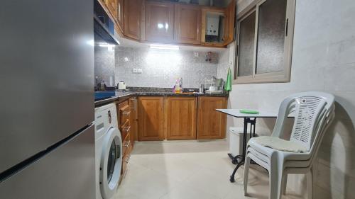 a kitchen with a washing machine and a table at Séjour confort 2 Wifi fibre optique & parking gratuit-Netflix in Midelt