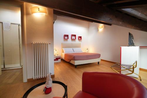a bedroom with a bed and a couch and a chair at My Loft in Ferrara