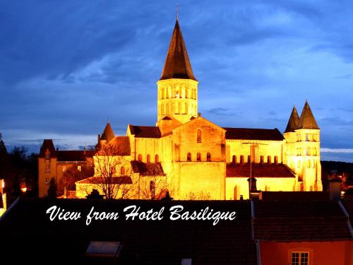 a large building with a clock tower at night at Hotel de la Basilique in Paray-le-Monial