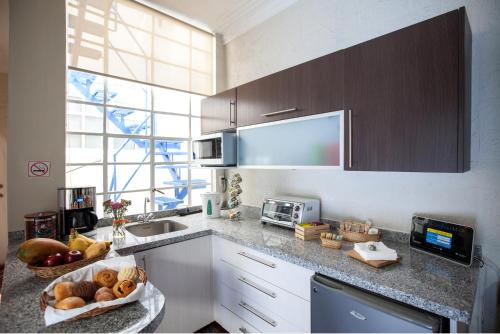 a kitchen with a sink and a bowl of fruit on a counter at Casa Condesa Amatlan 84 in Mexico City