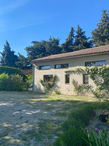 une maison en pierre avec des fleurs devant dans l'établissement Petite maison en Drôme provençale, à Tulette