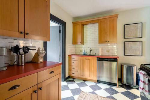 a kitchen with wooden cabinets and a checkered floor at Stay Portland - Moab Vibes in PDX- Walk to Local Coffee & Food in Portland