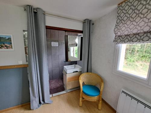 y baño con lavabo, silla y espejo. en Chambre d'Hôtes Valérie, en Penvénan
