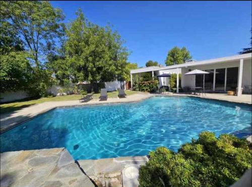 a large swimming pool in front of a house at Beautiful 4BD and 3BA Pool Jacuzzi Vacation Home in Los Angeles