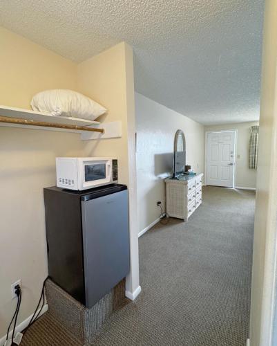 a room with a microwave on top of a refrigerator at The Jetty Motel in Cape May