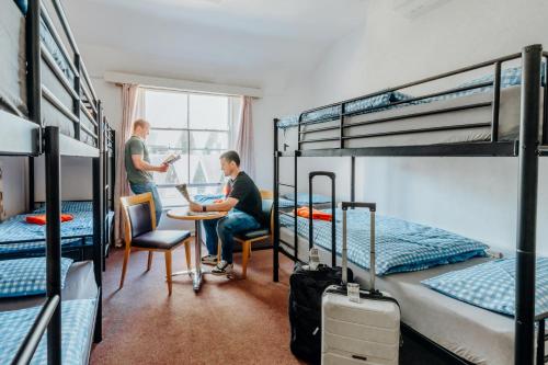 two men in a dorm room with bunk beds at Eden Quay Guesthouse Private Rooms in Dublin