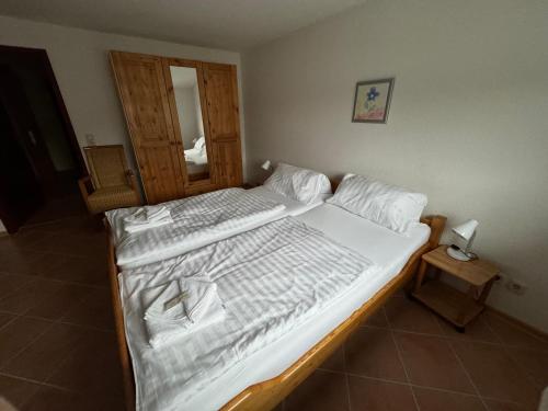 a bedroom with two beds with white sheets at Hotel Panorama in Wees