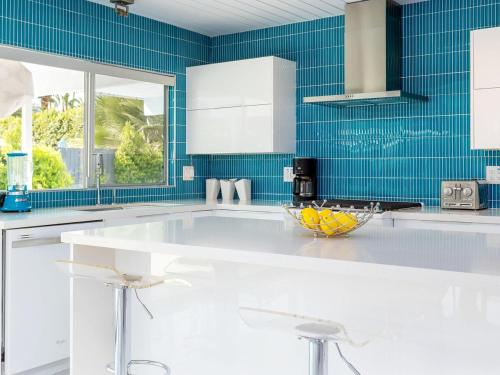 a kitchen with a white counter and blue tiles at As seen on HGTV Desert Flippers The Pink Door in Palm Springs