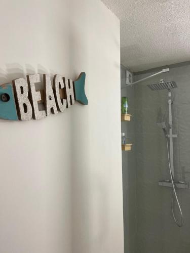 une salle de bain avec un panneau de poisson sur le mur dans l'établissement 50m de la MER, à Cavalaire-sur-Mer