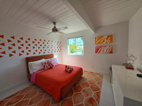 a bedroom with a bed with a red blanket at As seen on HGTV Desert Flippers The Pink Door in Palm Springs