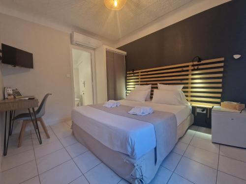a bedroom with a large bed and a table and a desk at Le Cosy in Saint-Aygulf