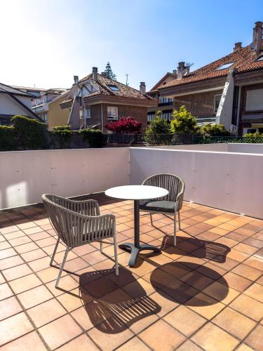 two chairs and a table on a patio at Hotel Verdemar in Ribadesella
