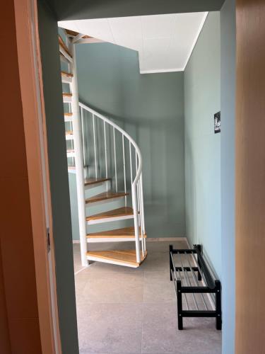 a staircase in a room with a bench next to it at Guesthouse Hvammur by the Harbour in Höfn