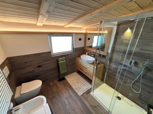 un baño con ducha y lavabo en Appartamento Cima 12, en Pozza di Fassa