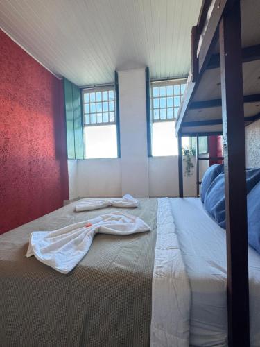 a bedroom with a bed with a robe on it at Pousada Cores do Pelô in Salvador