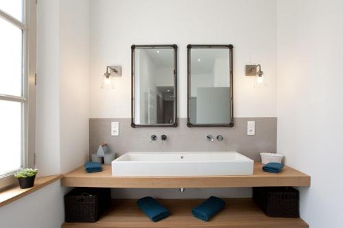 une salle de bain avec un lavabo blanc et un miroir dans l'établissement Appartement Le Belise, à Arles
