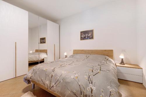 a white bedroom with a bed and a mirror at Casa Vacanze Leon Tremosine in Tremosine Sul Garda