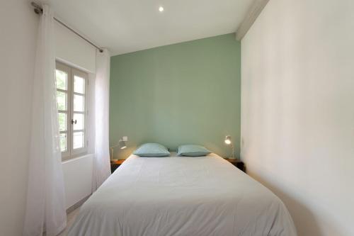 une chambre avec un lit avec deux oreillers bleus dessus dans l'établissement Appartement Le Belise, à Arles